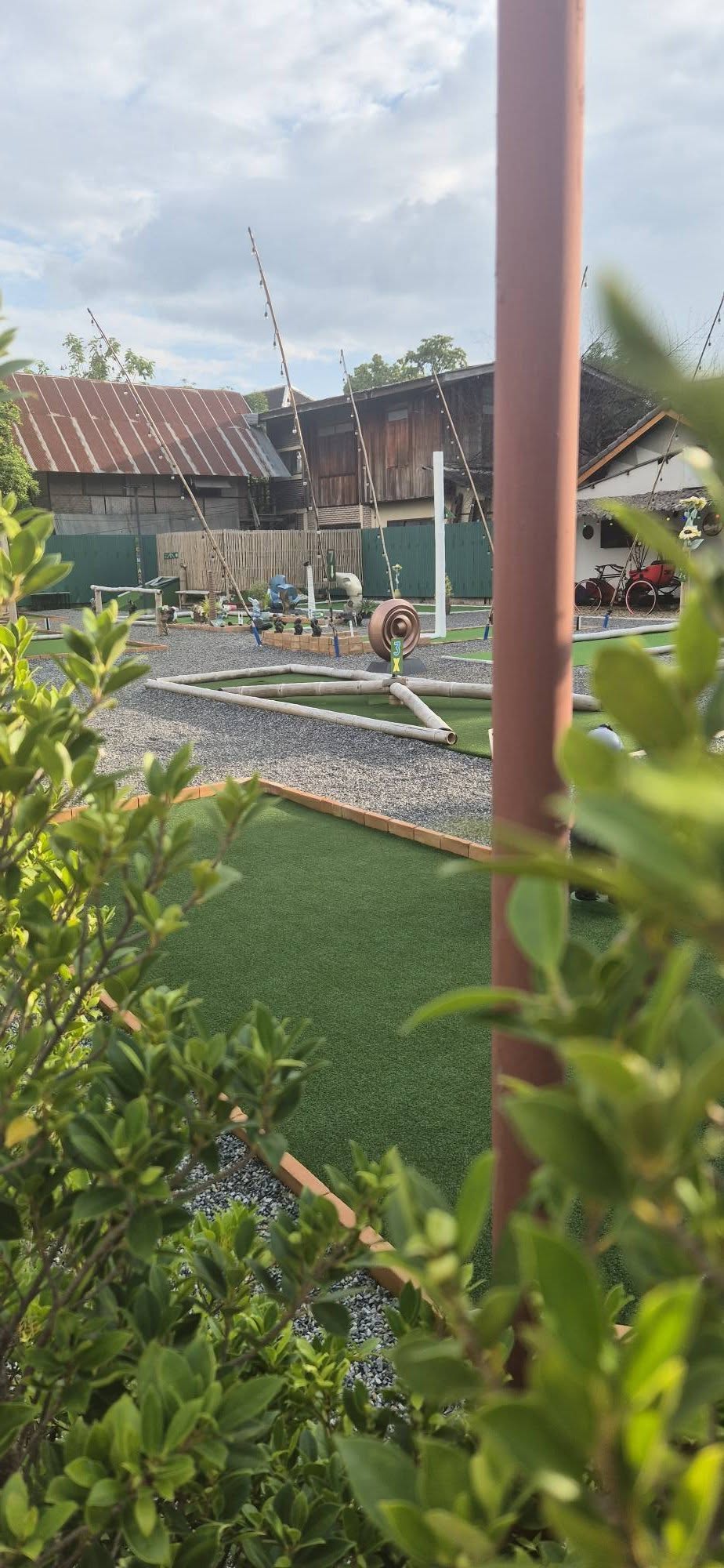 Mini golf fairway framed by leafy plants